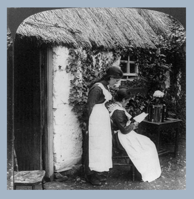Irish women reading letters from America in front of a thatched cottage.